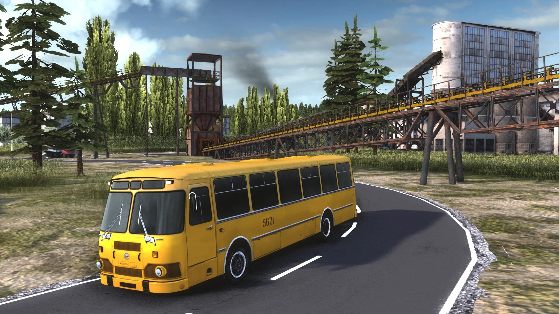 Yellow bus 5621 on a curved asphalt road, pines and a yellow conveyor leading to a concrete plant