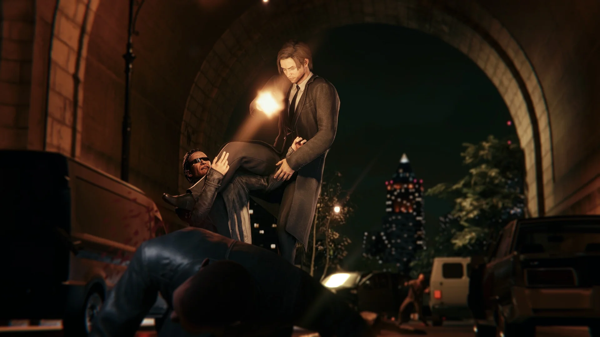 Takedown under a park arch: lifted man in sunglasses, another body in the foreground, lit tower behind
