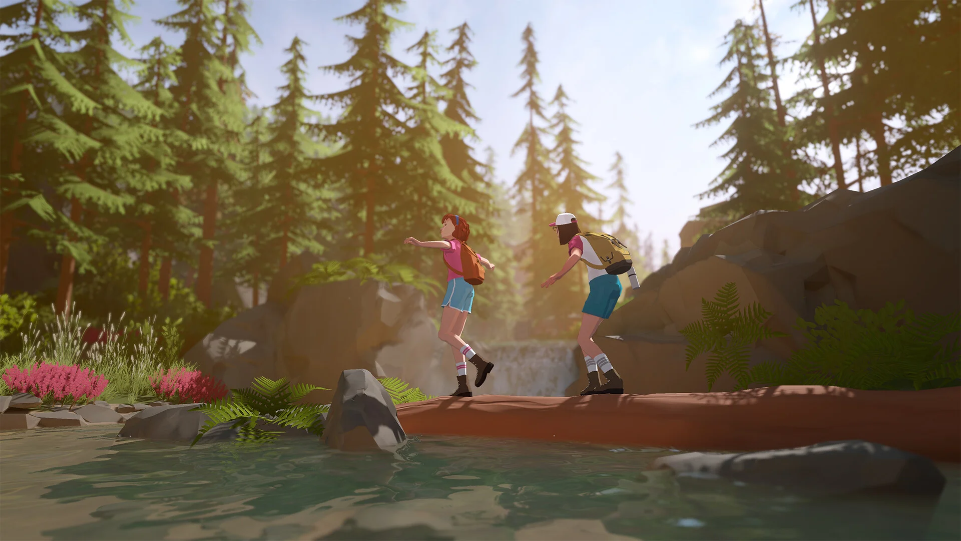 Two young women with backpacks balance on a fallen log over a forest creek, pines and pink flowers around the water