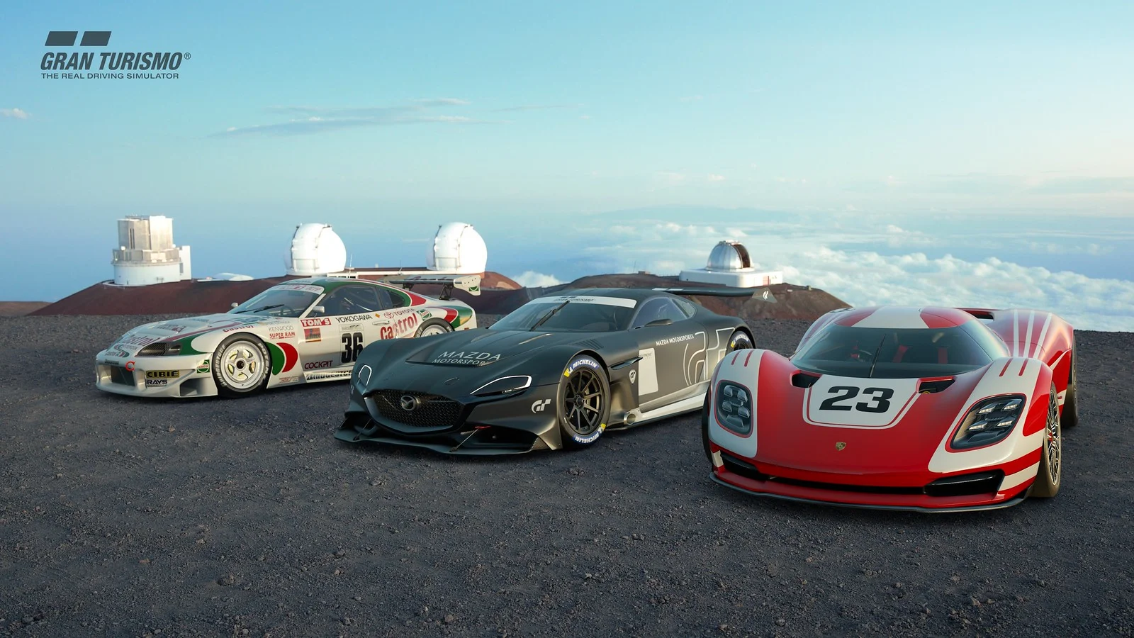 Several sports cars lined up at a desert observatory under a GT logo.