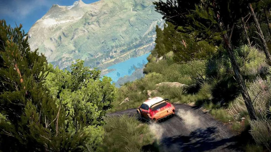 Red-and-white rally hatch kicking dust on a gravel shelf above a turquoise alpine lake, pines and a snow peak in sun