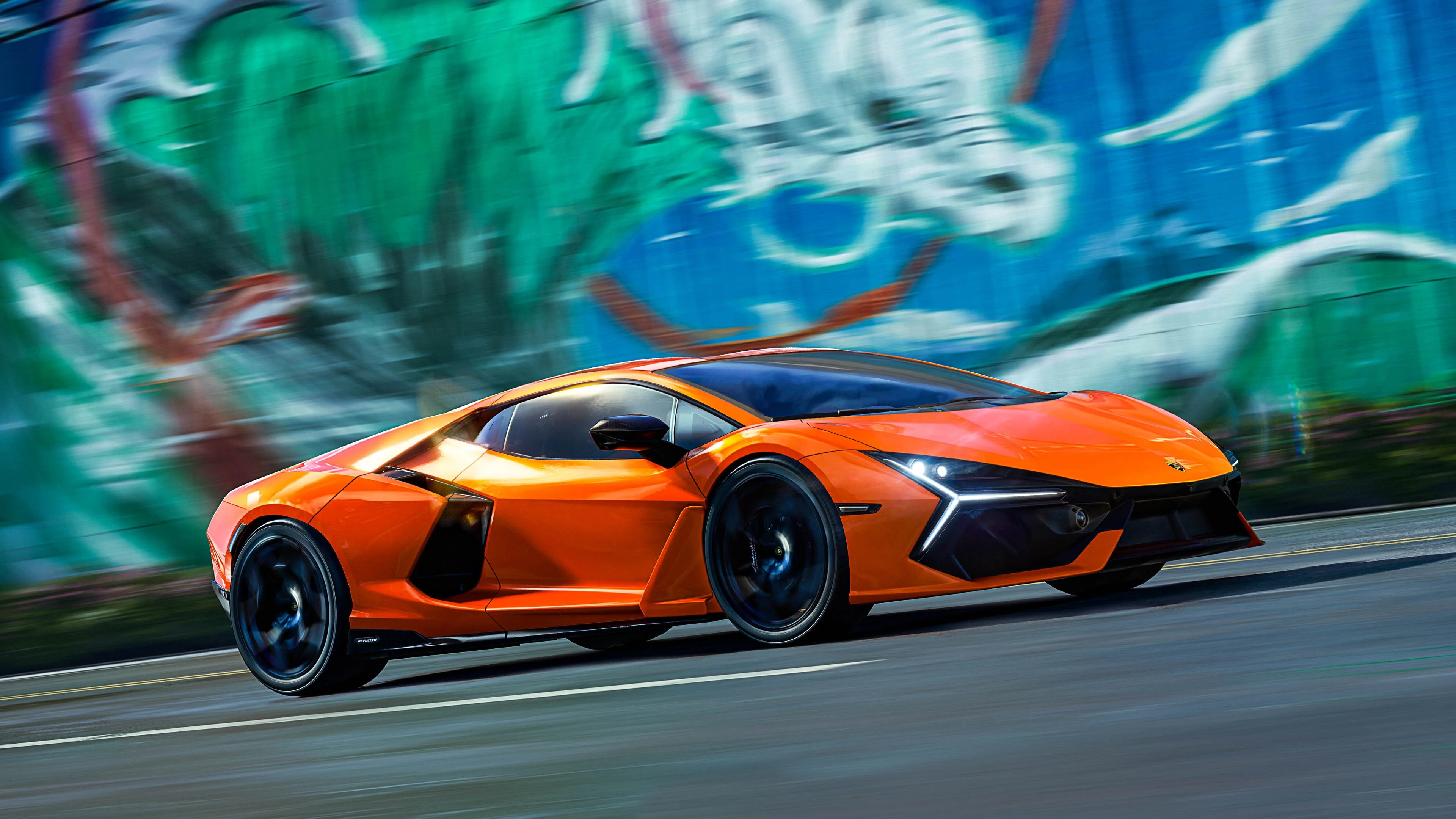 Orange supercar in side profile speeding past a blurred green-and-blue mural wall