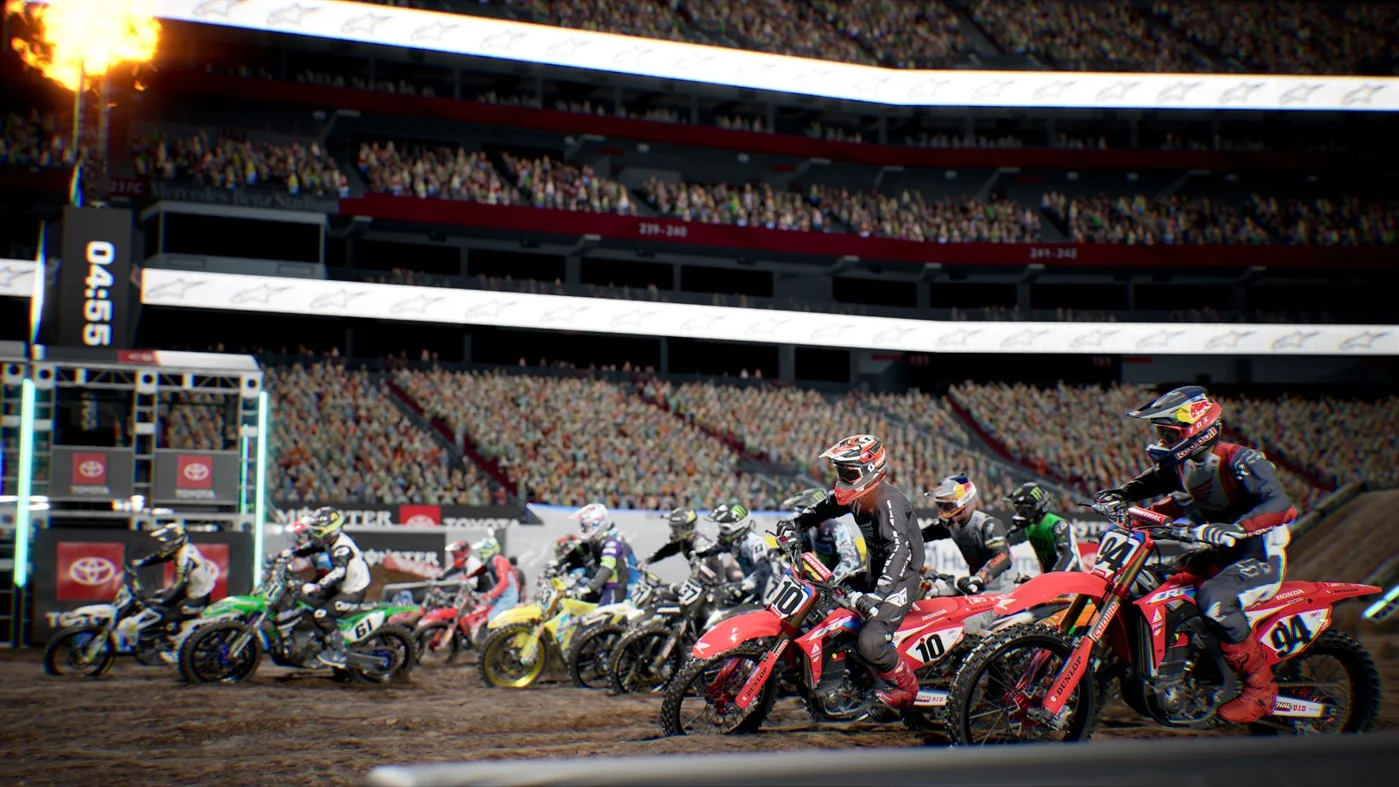 The first-turn pack in a packed stadium with Honda 10 and 94 on the inside line
