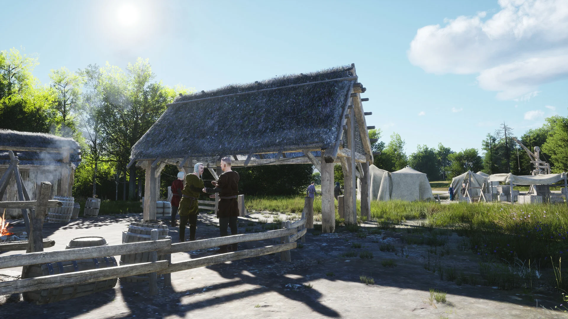 Two villagers talk under an open timber market roof beside barrels and a well