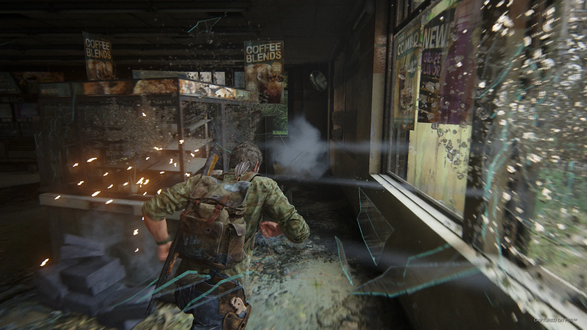 Joel runs past a shattered shop window with a rifle on his back and sparks in the air
