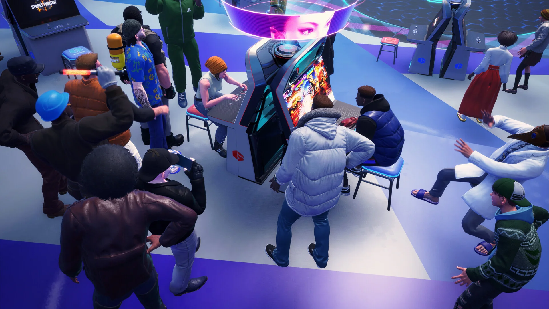 Overhead view of a packed Battle Hub floor, two sit-down cabinets and a hovering pink hologram face