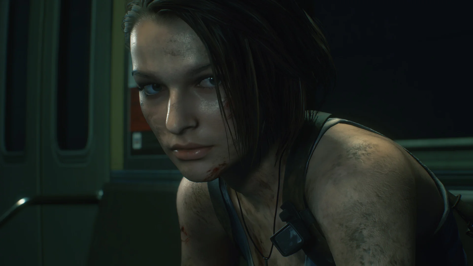 Close-up of a woman with a dirt-smeared face and tank top inside a dim metal corridor