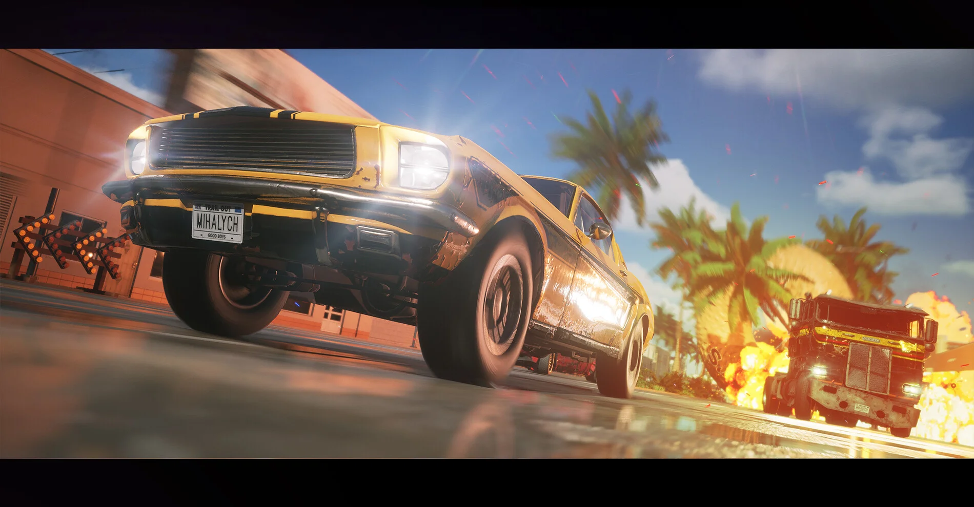 Yellow-black coupe plate MIHALYCH jumping past palms, a burning truck behind, low camera, blue sky