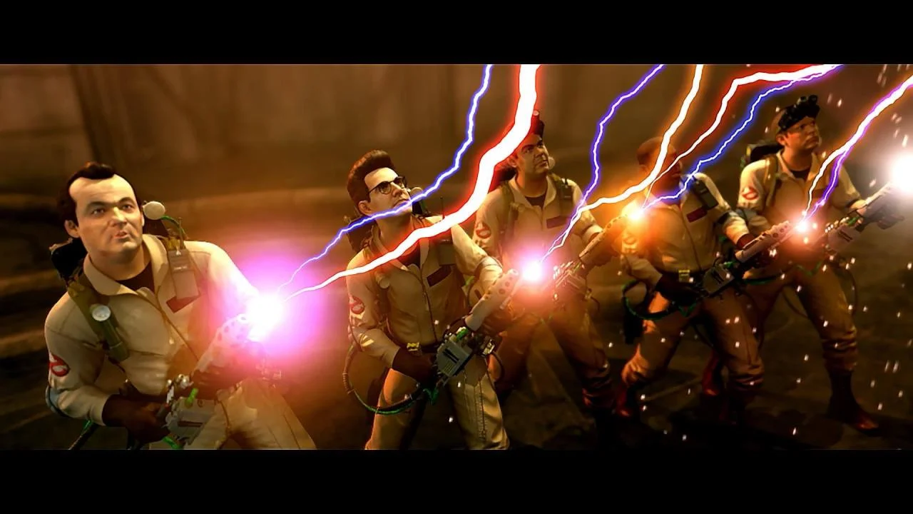 Four Ghostbusters fire proton streams in a dark stone room.
