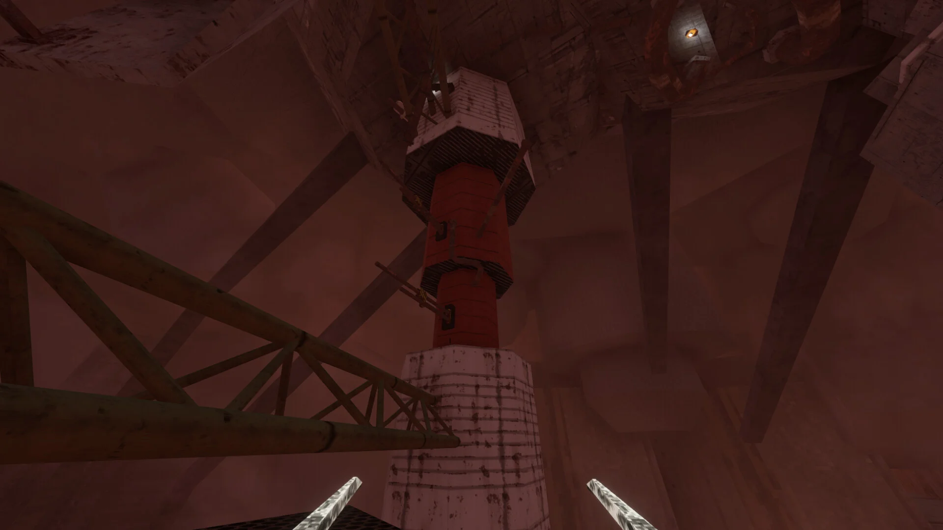 Looking up a red-and-white industrial pillar in a dusty red chamber, pickaxe tips at the bottom