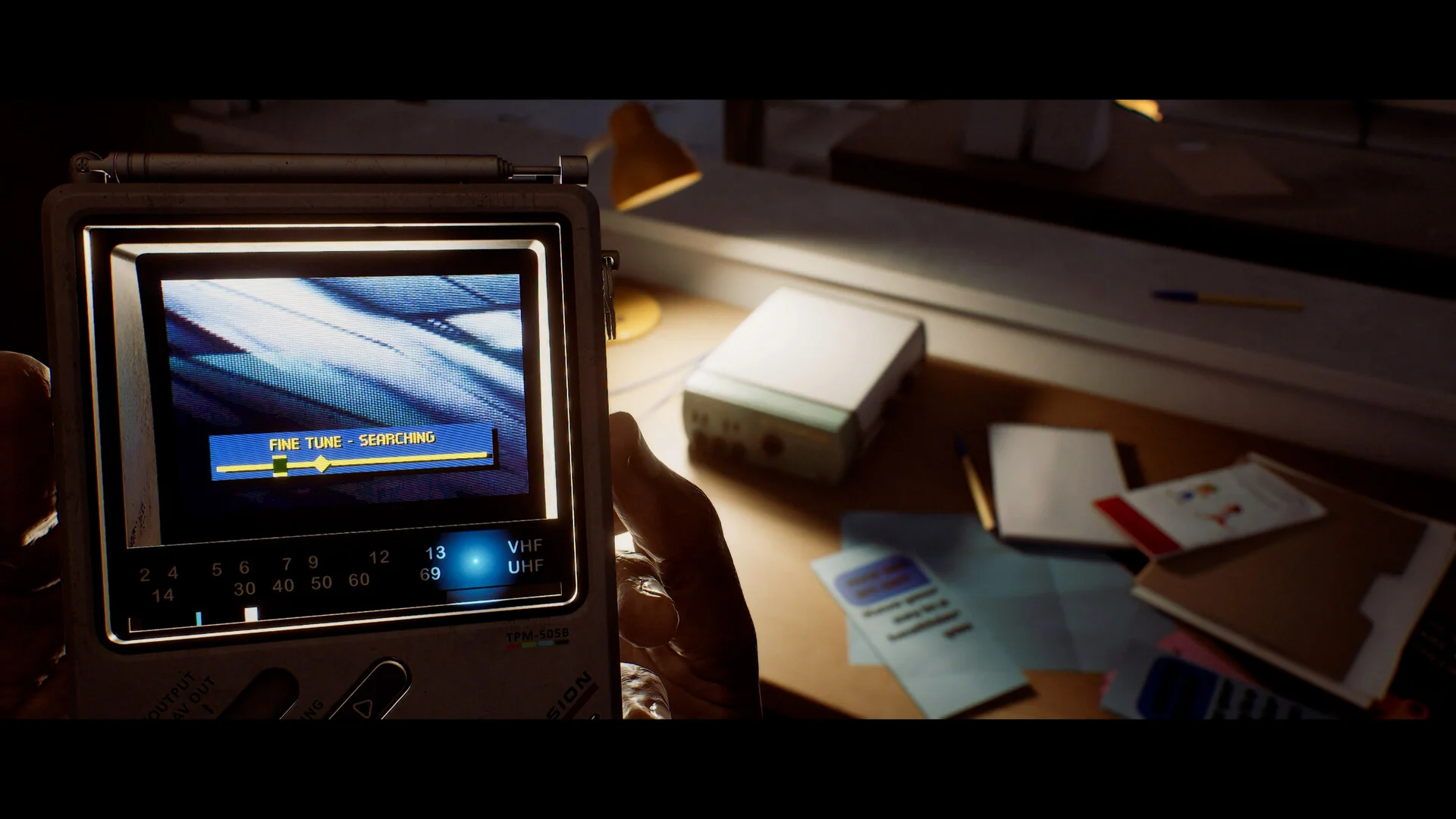 The CRTV screen shows a fine-tune search above a desk lamp and scattered papers