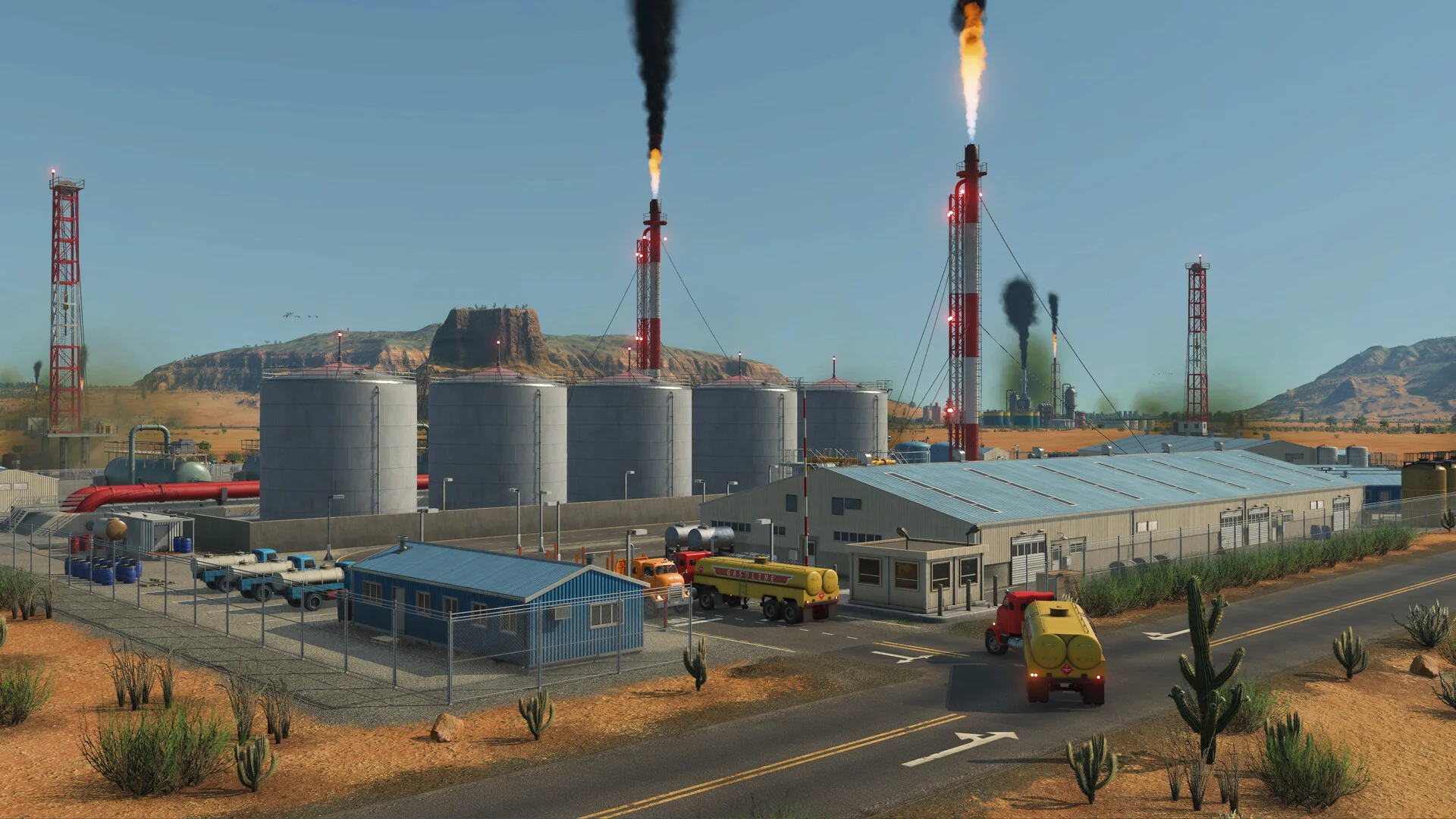 Desert industrial plant with silver storage tanks, flare stacks and a yellow tanker truck on a cactus-lined road