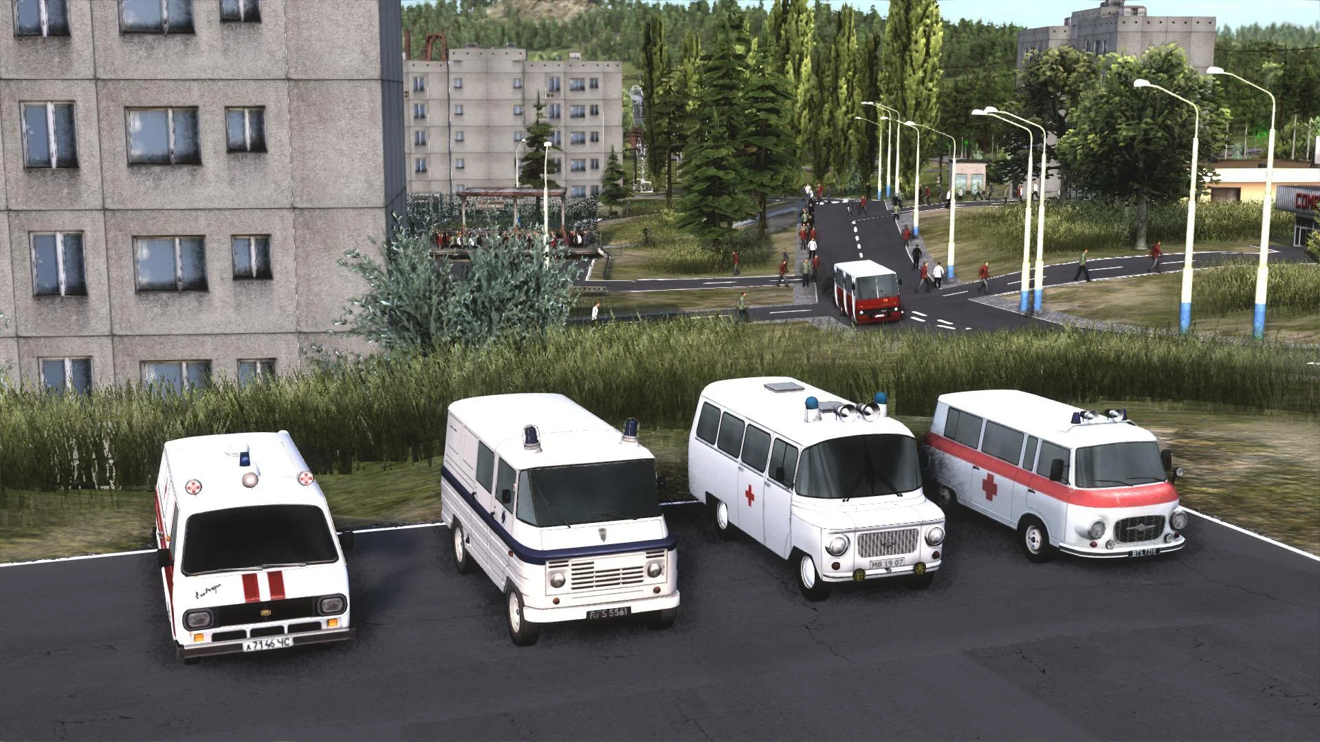 Four white ambulances parked in a row, two with red crosses, apartment block and a distant red van at a junction