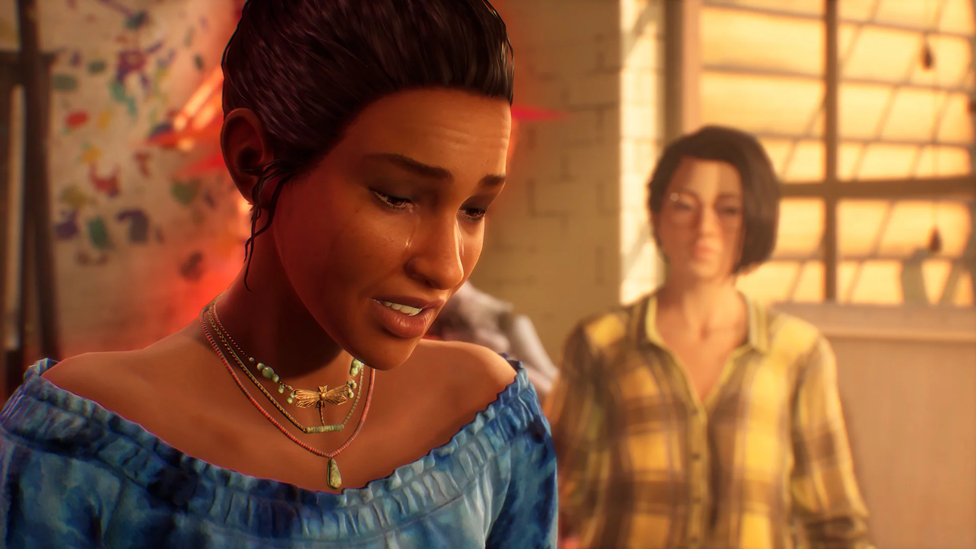Alex in a blue off-shoulder top beside a person in a plaid shirt.