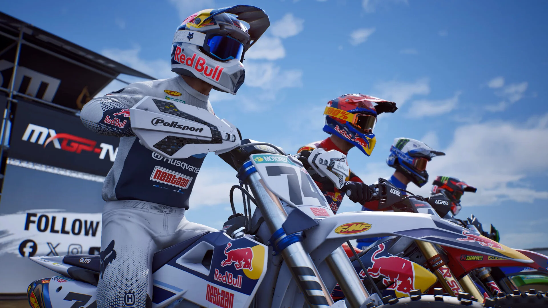 Four riders on the start line, number 74 in white Red Bull Husqvarna kit beside Red Bull KTM and Honda bikes, MXGP-TV board behind