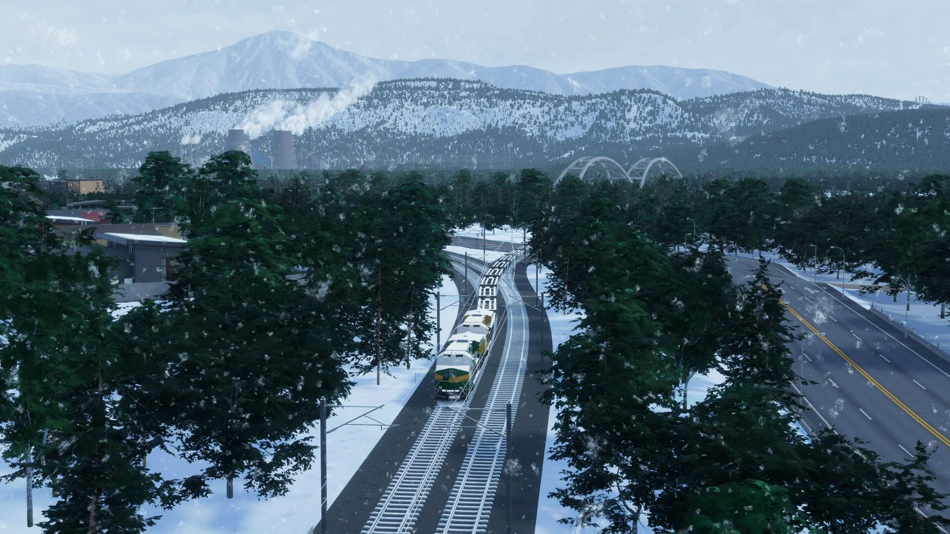 Snowy highway with a train, trees, and mountains
