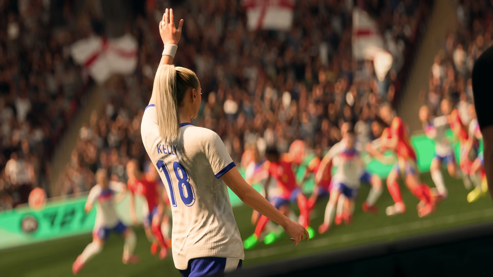 A player in a white shirt, Kelly 18, raises an arm toward a crowd with England flags