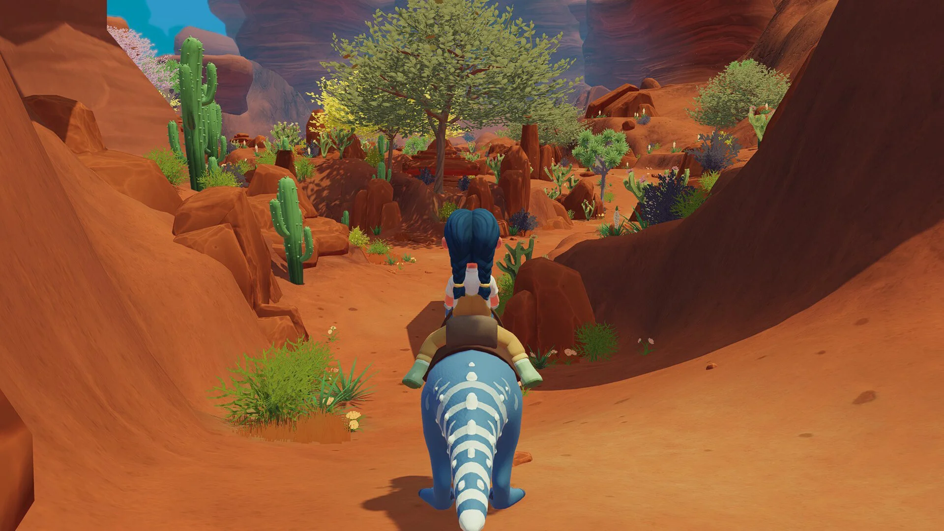 Ariacotta canyon: blue dino down red stone, cactus, braided rider heading into the wash