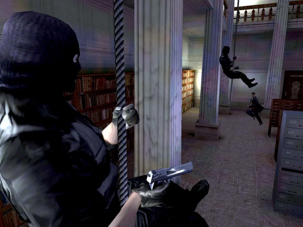 A hooded gunman aims a pistol as Max Payne slides a rope in a columned hall