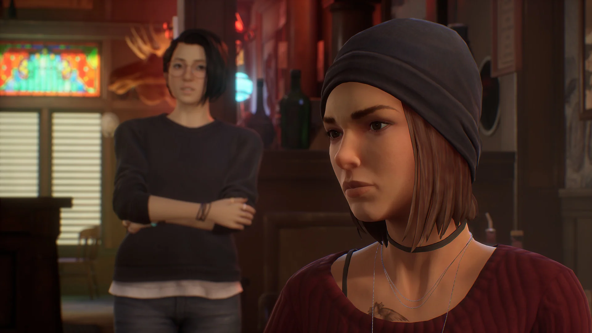 Alex facing a woman with short brown hair in a maroon sweater.