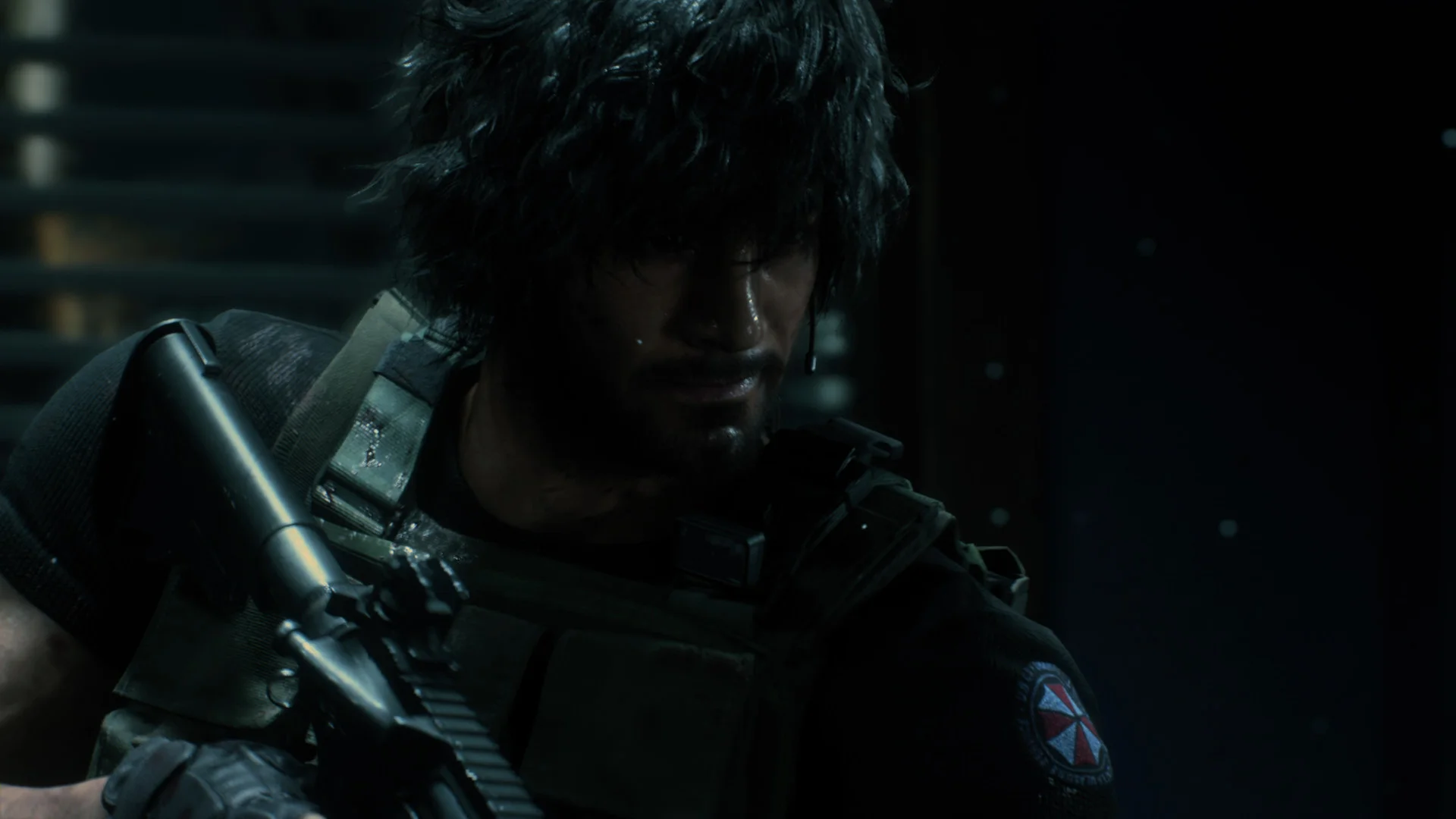 Close-up of a bearded operator in a dark vest with an Umbrella patch holding a rifle