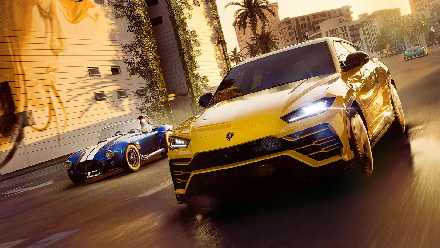 Yellow Lamborghini Urus and a blue striped Cobra race a city street at golden hour past a mural and palm trees