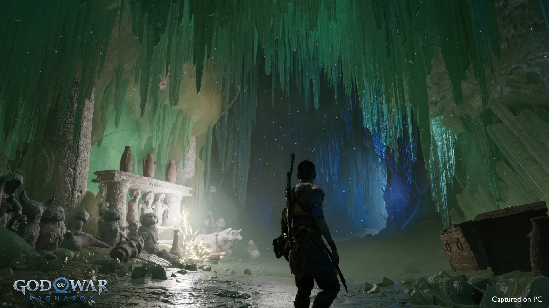 Atreus stands in a green ice cave with a bow on his back, facing a starry opening