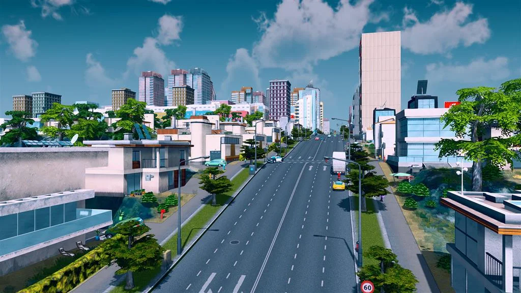 Six-lane boulevard marked 60 running from houses toward downtown towers