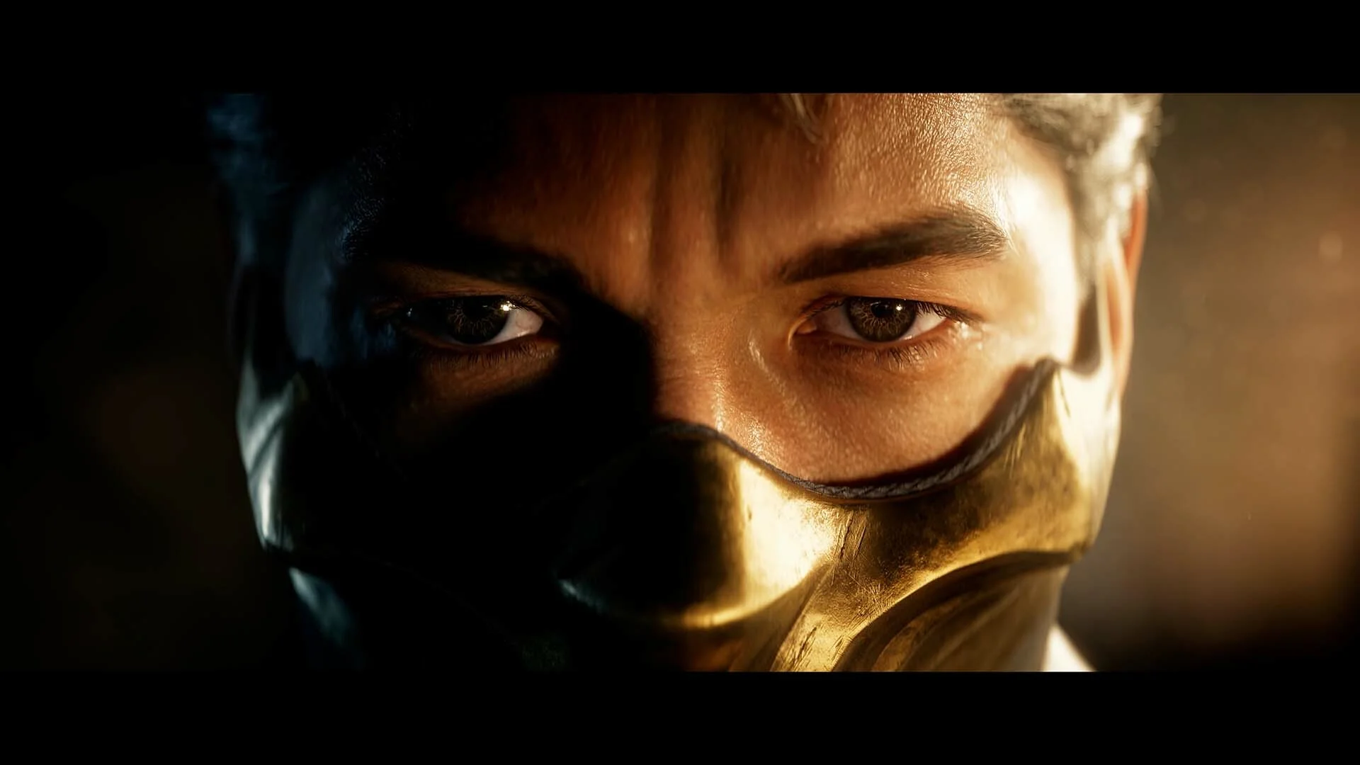 Close-up of a fighter's eyes above a gold half-mask in low light